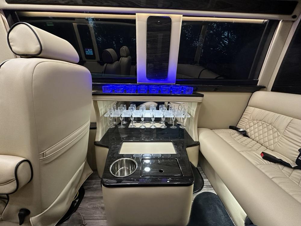 The table inside the van, set with glassware, beside a leather bench seat